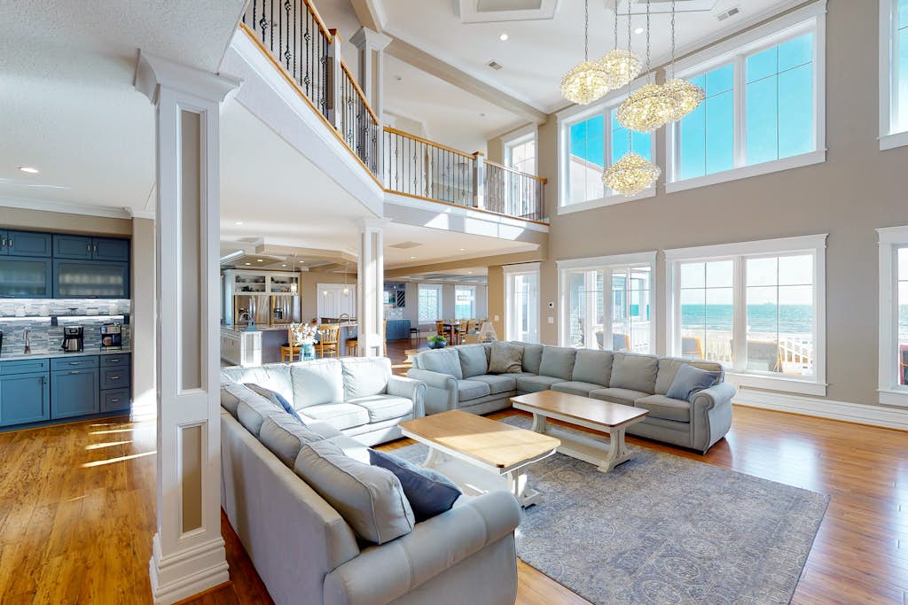 Bright oceanfront living room and open-concept kitchen with panoramic windows