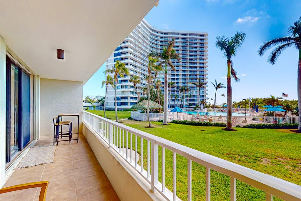 Balcony view of a lawn and pool from a VueStay Southwest Florida condo rental