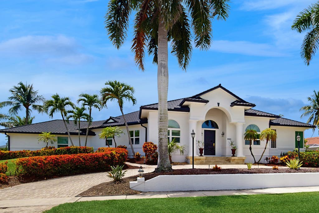 White stucco VueStay vacation home with palm trees in Southwest Florida