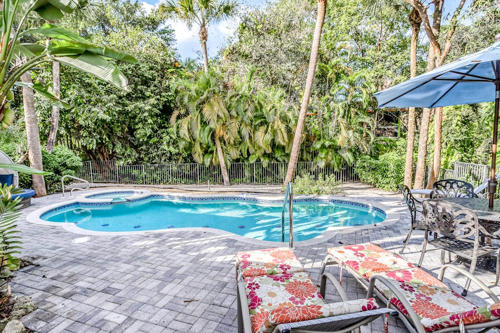 Private pool and lanai at a VueStay vacation rental surrounded by palms