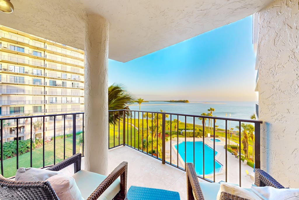 Balcony view of the Gulf and pool from a VueStay beachfront condo